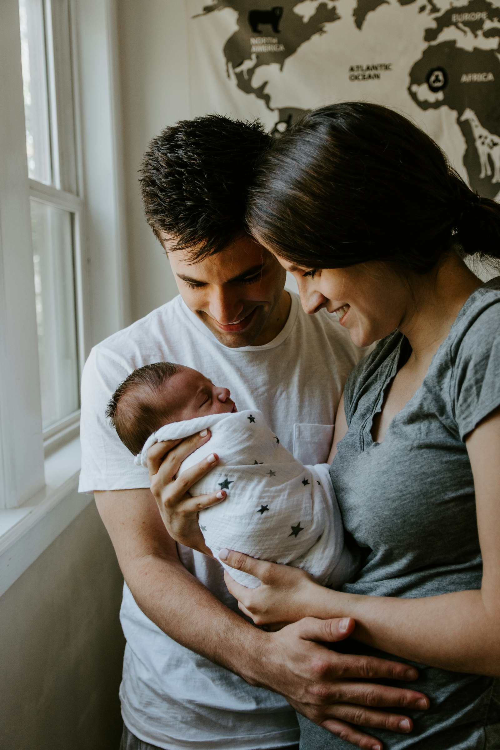Parents holding their newborn child at home, representing the families AZK Insurance protects